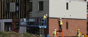 Construction workers build affordable housing units.
