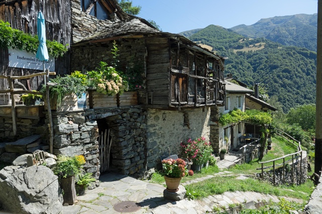 Yours for CHF1: a stone cottage in Indemini, with the pastures of Sciaga in the background (Keystone) Vista di un nucleo di paese con case in pietra e legno; dietro, montagna con due pascoli ben visibili
