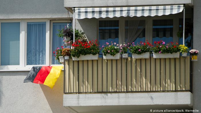an apartment balcony with a German flag (picture alliance/dpa/A. Warnecke )