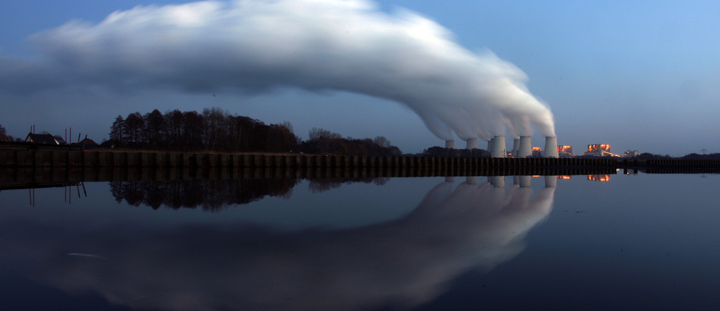 Steam billowing from the cooling towers of Vattenfall's Jaenschwalde brown coal power station is reflected in the water of a lake near Cottbus, eastern Germany December 2, 2009. Most world leaders plan to attend a climate summit in Copenhagen December 7-18, boosting chances that a new U.N. deal to fight climate change will be reached, host Denmark said on Tuesday. REUTERS/Pawel Kopczynski (GERMANY - Tags: ENVIRONMENT ENERGY) - BM2E5C21AYQ01