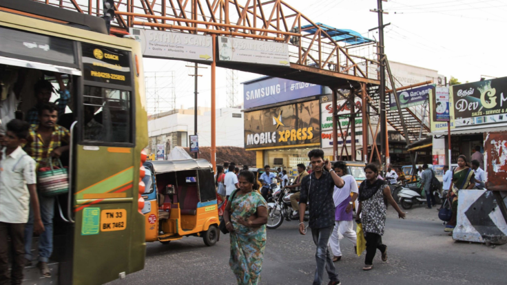 People walk beneath pedestrian bridge