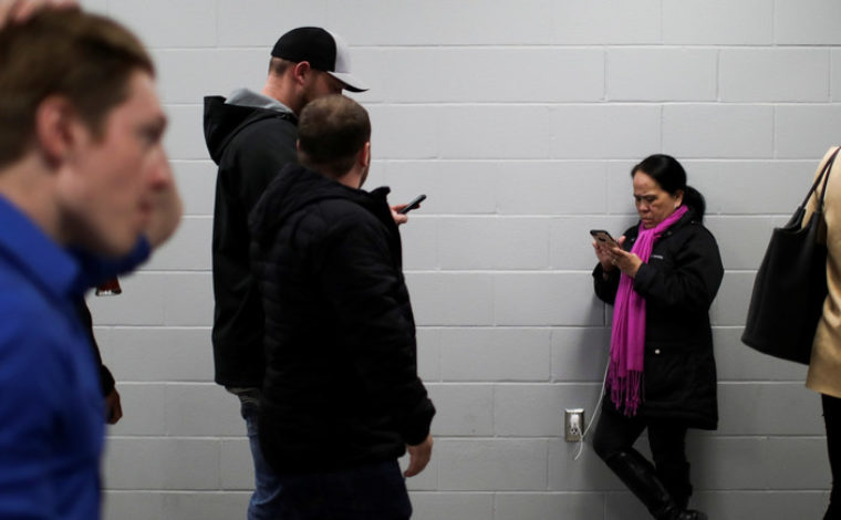 A woman checks her phone as the results come in at the Conservative leader Andrew Scheer