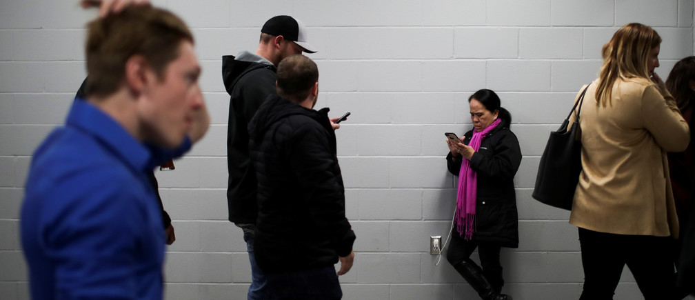 A woman checks her phone as the results come in at the Conservative leader Andrew Scheer's campaign headquarters during the federal election in Regina, Saskatchewan, Canada October 21, 2019. REUTERS/Carlos Osorio - RC16E067C660