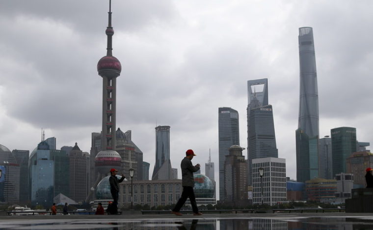 People walk on the bund in front of the financial district of Pudong in Shanghai, China March 9, 2016. REUTERS/Aly Song - GF10000338954