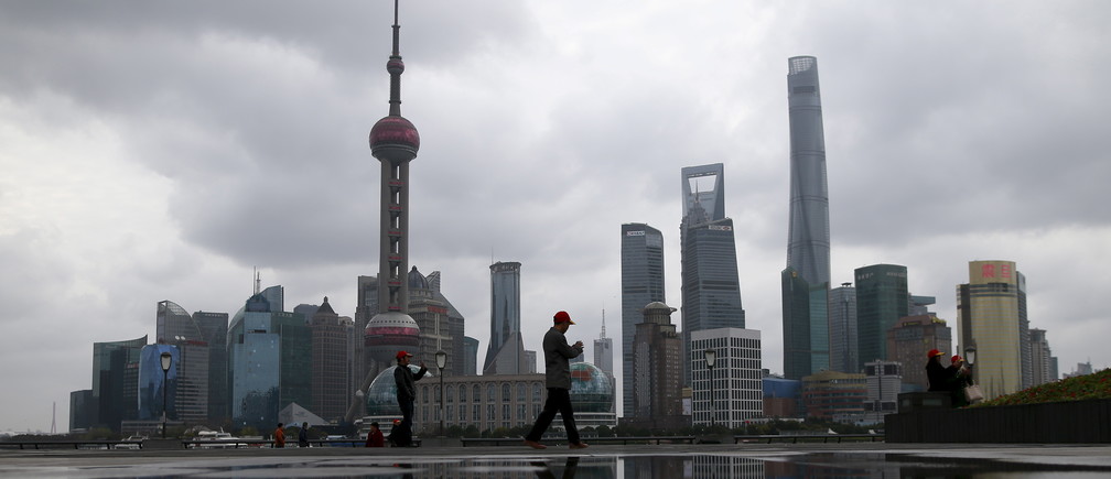 People walk on the bund in front of the financial district of Pudong in Shanghai, China March 9, 2016. REUTERS/Aly Song - GF10000338954