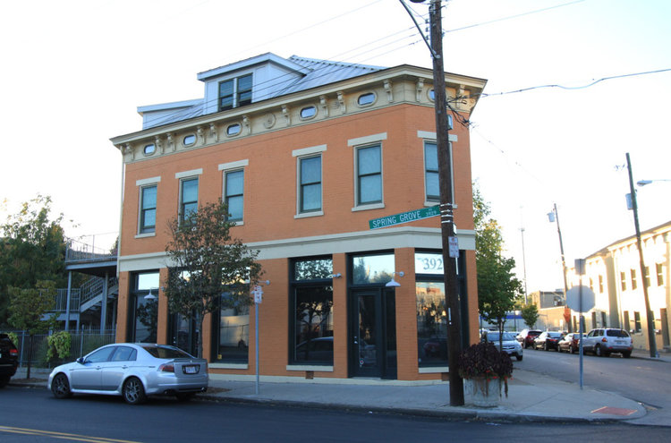 This is a simple mixed-use, multi-family building with a business on the bottom floor and a few housing units on the top floors. (Source: Johnny Sanphillippo)